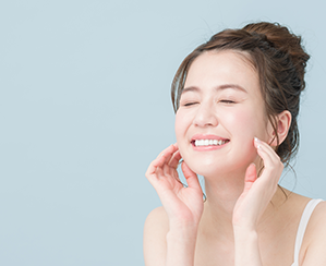 女性が頬に両手を当てている写真